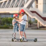 Ninebot-KickScooter-ZING-C10-and-C8_Lifestyle-picture_Boy-putting-Segway-helmet-to-girl