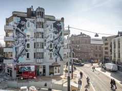 Torenhoge muurschildering tegen klassenongelijkheid op het Leidseplein in Amsterdam